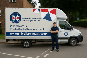 A professional Umbrella Removals & Storage mover in a navy uniform stands beside a branded white van on a residential London street.